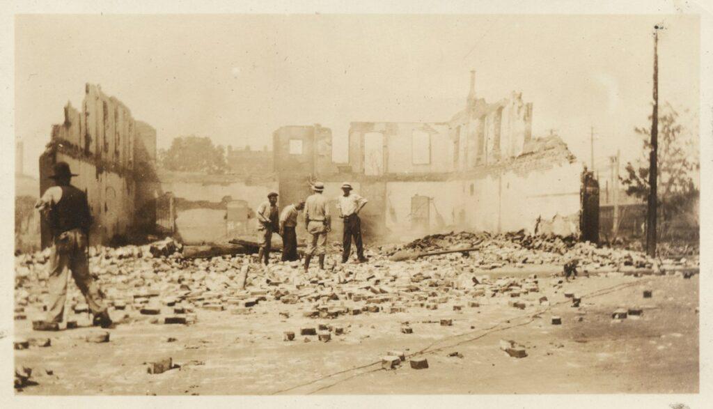 Surveying the damage, men look over a building that has been reduced to rubble.